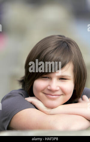 Young girl resting her head on her arms and smiling Stock Photo