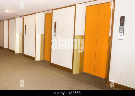 elevators orange color in hotel lobby . Stock Photo