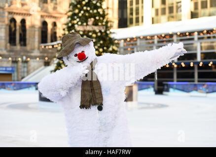 An actor plays The Snowman during a photo call at the Natural History Museum Ice Rink for the theatre production of The Snowman, running at the Peacock Theatre in London. Stock Photo