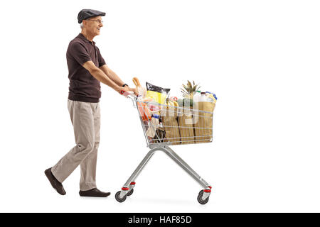 Full length profile shot of an elderly man pushing a shopping cart filled with groceries isolated on white background Stock Photo