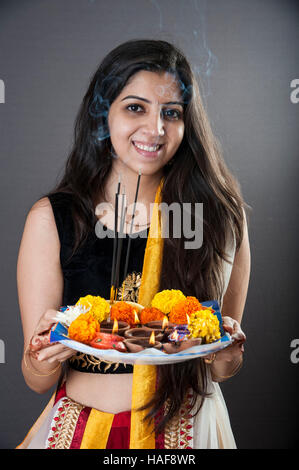 a girl smiling and holding a traditional Diwali thali Mumbai maharashtra India Stock Photo