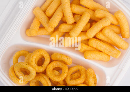 top view close up of potato and corn junk food ingredients in a white take away packaging box on yellow background, calories concept Stock Photo