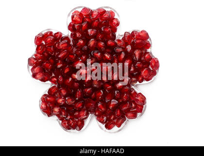 rich red pomegranates seeds arranged in a flower shape on a isolated white background. ideal for patten work Stock Photo
