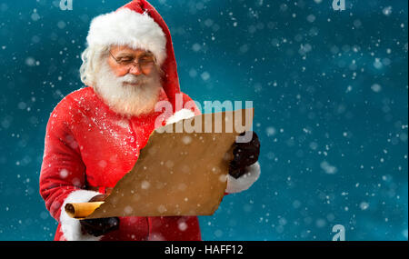 Kind Santa Claus reading vintage paper with wishes. Merry Christmas & New Year's Eve concept. Stock Photo