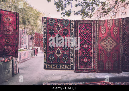 Armenian traditional carpets with traditional ornaments and patterns for sale in Yerevan Armenia. Old fashioned sepia colors. Stock Photo