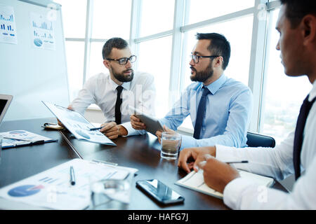Economists or analysts discussing financial data Stock Photo