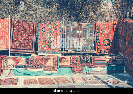 Armenian traditional carpets with traditional ornaments and patterns for sale in Yerevan Armenia. Old fashioned sepia colors. Stock Photo