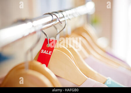 Red sale tag on hanger with dress or blouse Stock Photo