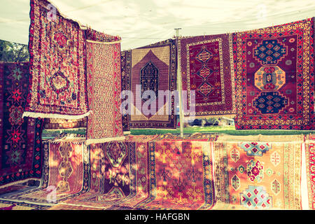 Armenian traditional carpets with traditional ornaments and patterns for sale in Yerevan Armenia. Old fashioned sepia colors. Stock Photo