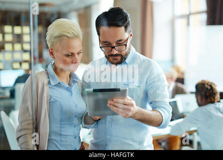 Two young professionals searching for creative ideas in the net Stock Photo