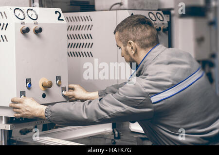 Worker Operating Welding Machine in Factory. Plastic Window and Door Industry Production. Stock Photo