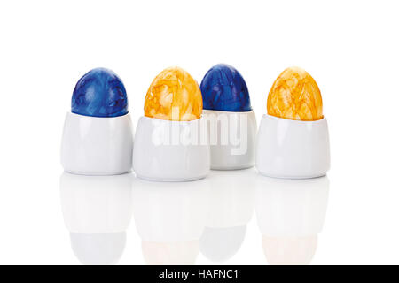 Four colored easter eggs in egg cups Stock Photo