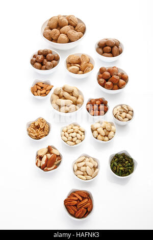 Assorted nuts in porcelain bowls, pecans, walnuts, hazelnuts, macadamia nuts, peanuts, almonds, pistachios Stock Photo