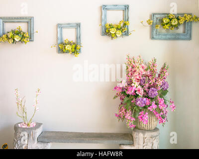 Pink and purple bouquet of flowers in a vase on the white wall Stock Photo