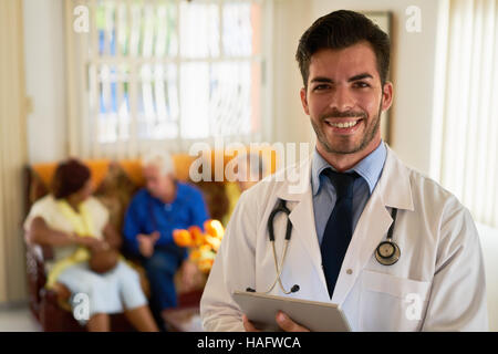 Portrait of young doctor at work as physician in hospital for seniors. Man working in hospice with elderly people, health care professional Stock Photo