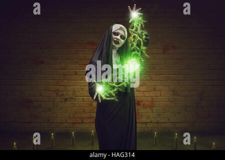 Scary devil nun for halloween concept image. She is casting satanic spell Stock Photo