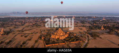 Hot air balloons flying over the temples of the Archaeological Zone in Bagan in the early morning sunlight. Myanmar. Stock Photo