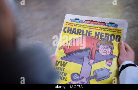ILLUSTRATION - A person holds the first German edition of the French satirical magazine Charlie Hebdo, in Stuttgart, Germany, 1 December 2016. Photo: Lino Mirgeler/dpa Stock Photo
