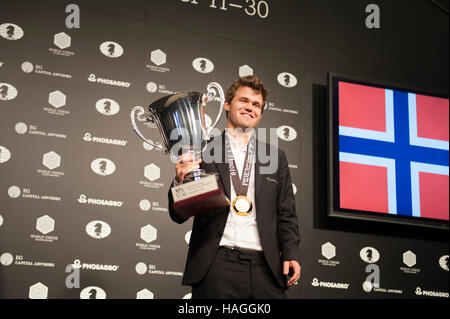 New York, USA. 30th Nov, 2016. Magnus Carlsen of Norway holding the prize cup on Nov. 30, 2016 after winning a 13-day match against Sergey Karjakin of Russia for the title of FIDE World Chess Champion — a title that Carlsen already held and had to defend. The match was held in the South Street Seaport in Manhattan, New York City. Credit:  Terese Loeb Kreuzer/Alamy Live News Stock Photo