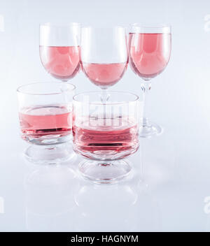 Rosè wine in stemmed glasses on white background with reflection Stock Photo