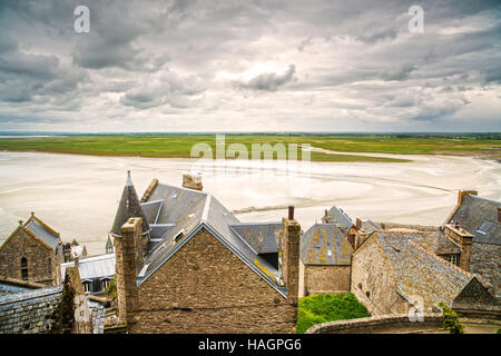 Mont Saint Michel monastery landmark and bay in low tide and bad weather. Normandy, France, Europe Stock Photo