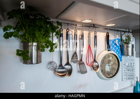 Various kitchen utensils hanging in a domestic kitchen. Stock Photo