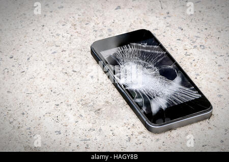 Smartphone with broken screen on the ground. Stock Photo