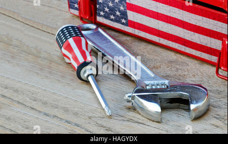 Phillips screwdriver with us flag printed  and lock wrench on wooden table. Stock Photo
