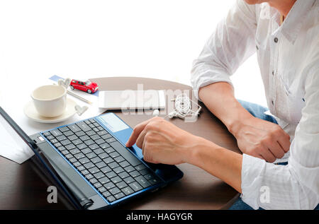 Side view of man using laptop with bright  light  background. Stock Photo