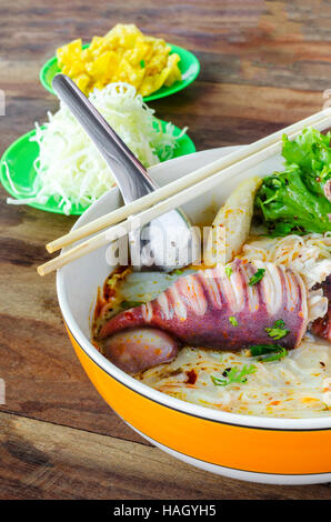 Bowl of Spicy Soup Noodle with Octopus egg on wooden table. Stock Photo