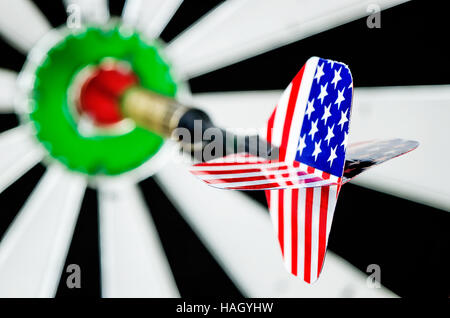Dart arrow with usa flag  hitting in the target center of dartboard,shallow DOF Stock Photo