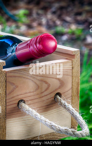 Bottle of red wine  in the wooden box,close up view. Stock Photo