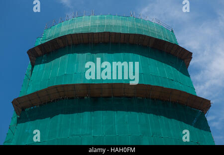 Building is under construction, protected by green netting  cover Stock Photo