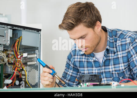 Male computer technician using soldering iron Stock Photo