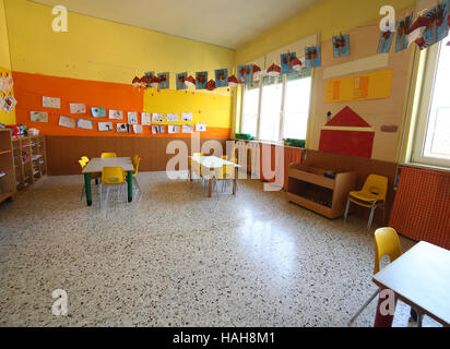 classroom of a childhood nursery with drawings and the tables and small chairs Stock Photo