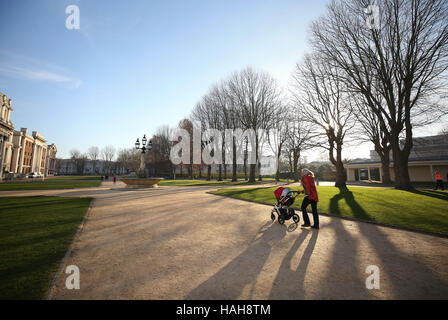 A woman pushes a pram in the Old Royal Naval College in Greenwich, after one of the coldest nights of the autumn so far this year across England and Wales. Stock Photo