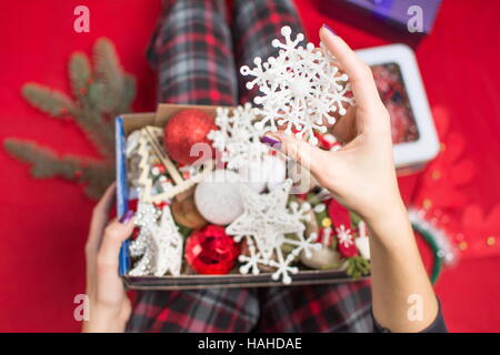 female holding an opened christmas  decoration box in pyjamas Stock Photo