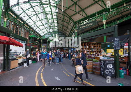 LONDON - OCTOBER 31, 2016: Visitors browse the specialty food stalls at Borough Market, one of the largest and oldest in town. Stock Photo