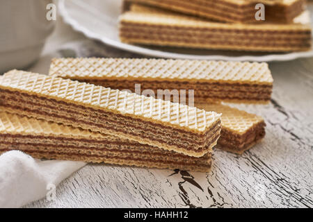 Wafer biscuits with chocolate cream on white rustic wooden background Stock Photo