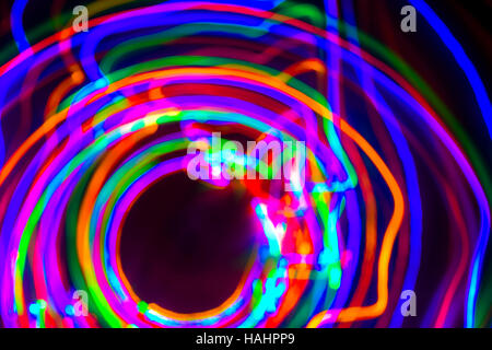 Christmas tree lights spun around to achieve a spiral glowing effect; abstract circular color trails, defocused, abstract Stock Photo