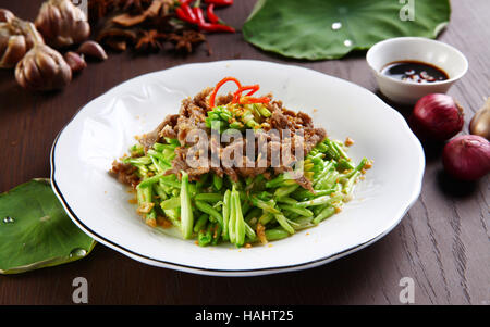 Fried beef with lily flower on the table with onion, sauce and garlic Stock Photo