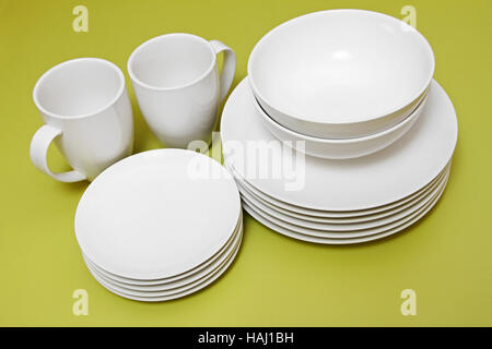 clean plates bowls and cups on green table Stock Photo