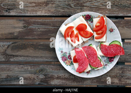 plate with variety of cheese snacks on wooden table Stock Photo