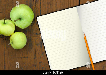 notebook with pencil and apples on a wood table Stock Photo