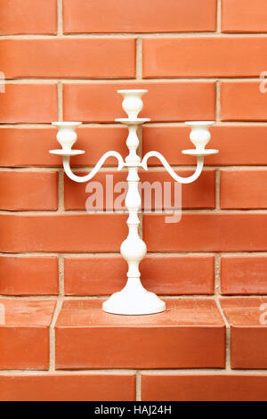 white candlestick on the brick background Stock Photo