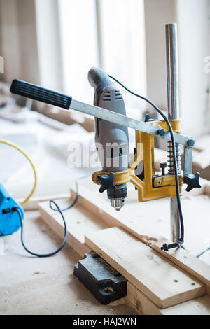 Screw and electric drill on wood at workshop Stock Photo