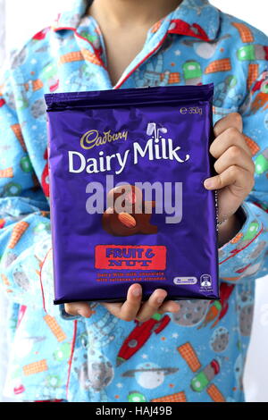 Close up of male child hand holding Cadbury chocolate fruit and nut bar Stock Photo