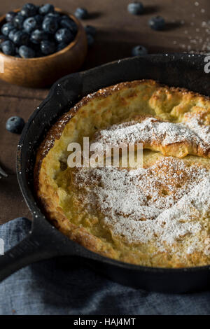 Homemade Dutch Baby Pancake with Blueberries and Powdered Sugar Stock Photo