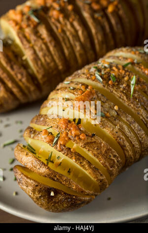 Homemade Cheesy Hasselback Potato with Fresh Herbs Stock Photo