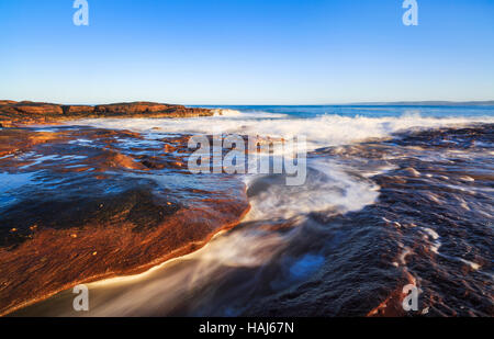 Waves breaking on the rocky sandstone shoreline below Red Bluff in Kalbarri National Park Stock Photo